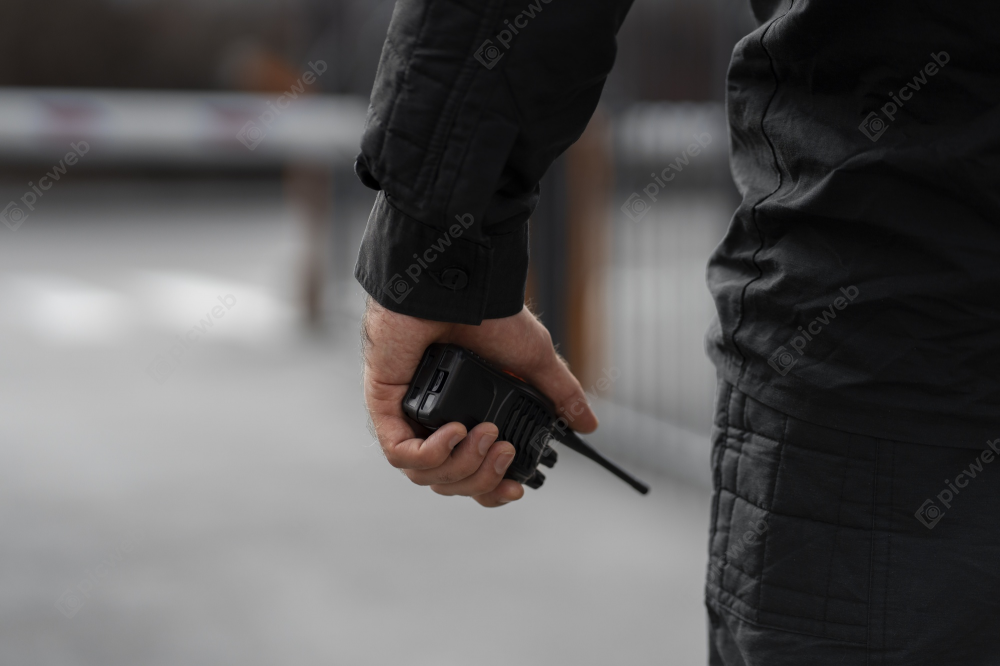 Мужчина с рацией в черной одежде