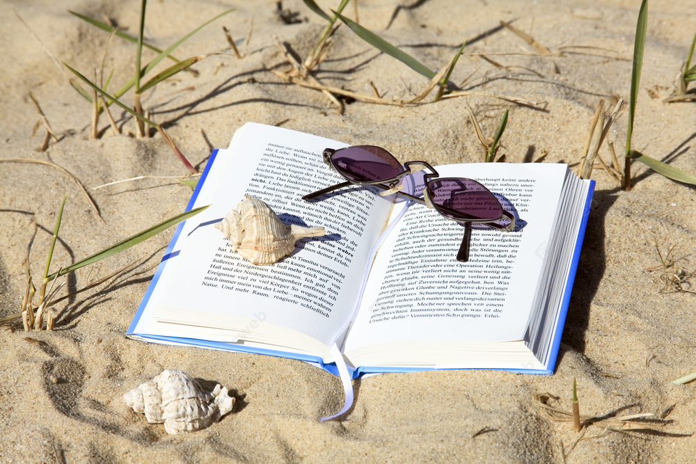 Книга и пляжные атрибуты на песке