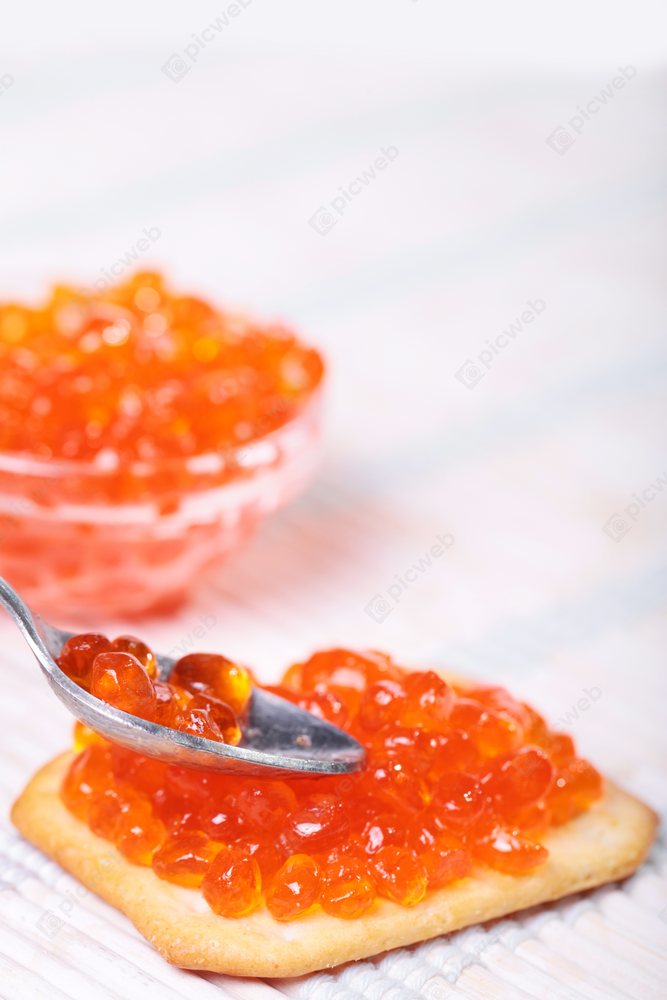 Ложка с красной икрой на фоне